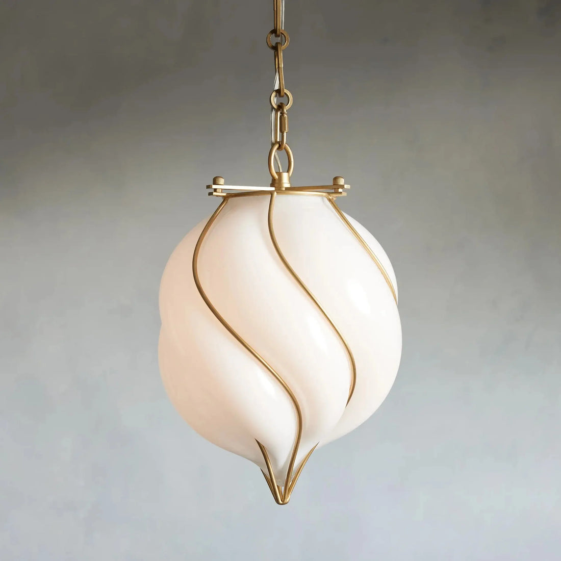 Decorative pendant light with a white glass shade and gold accents on a plain background