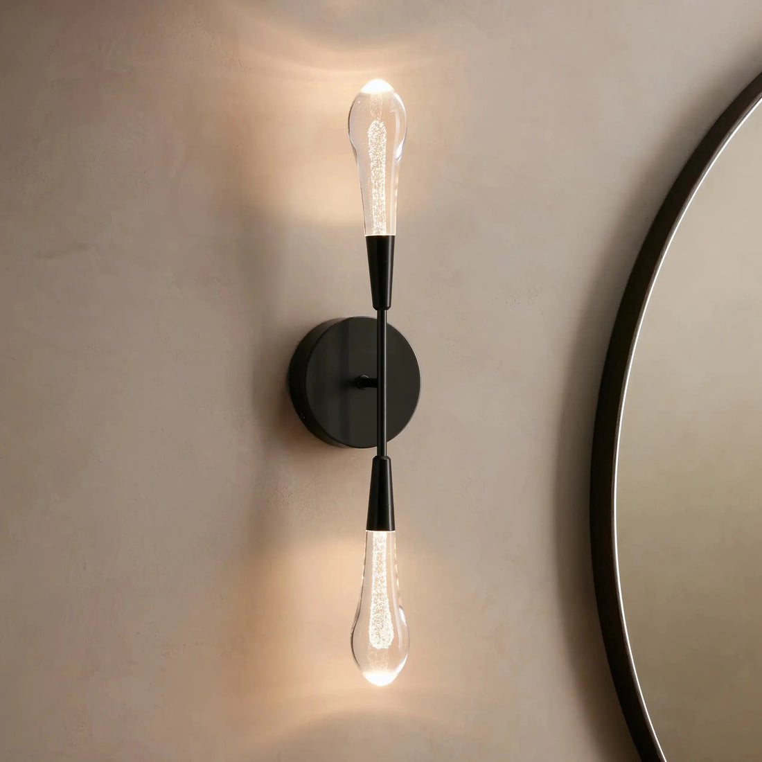 Gold wall sconce with a round mirror on a beige wall